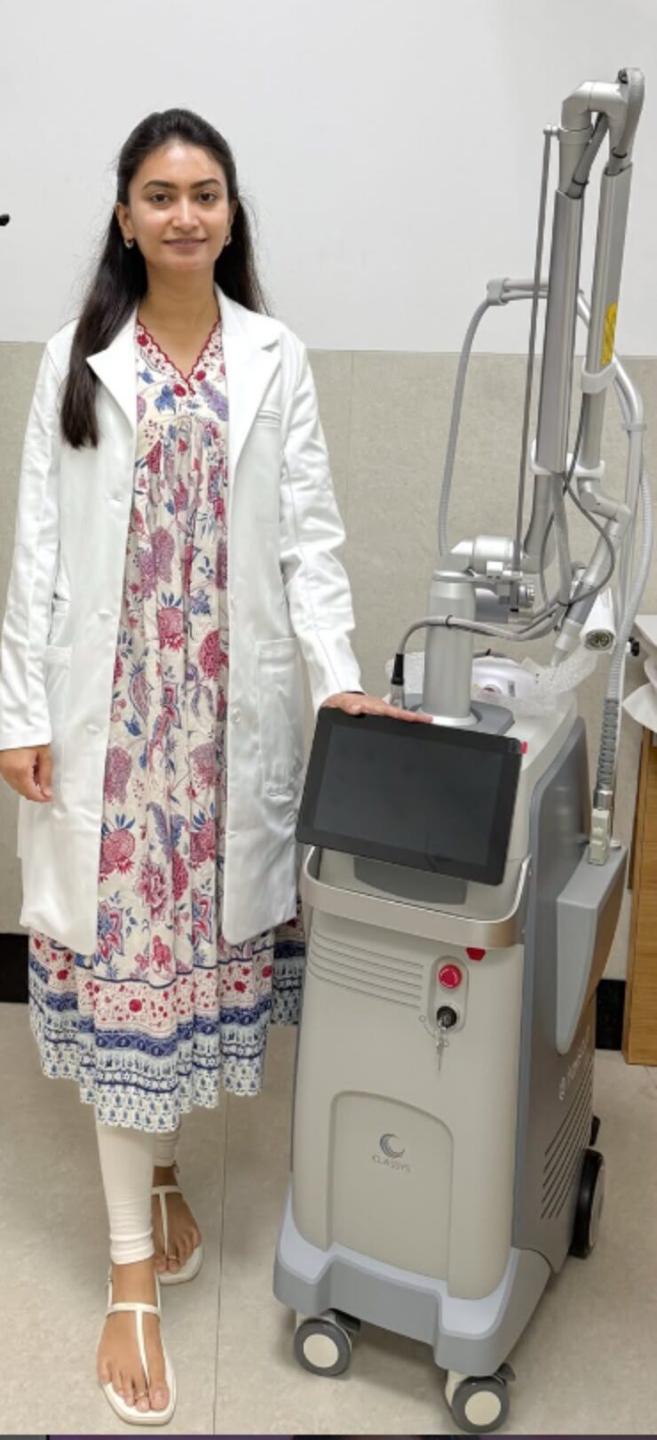 Dr. Shri Sindhuja in clinic beside dermatology laser equipment